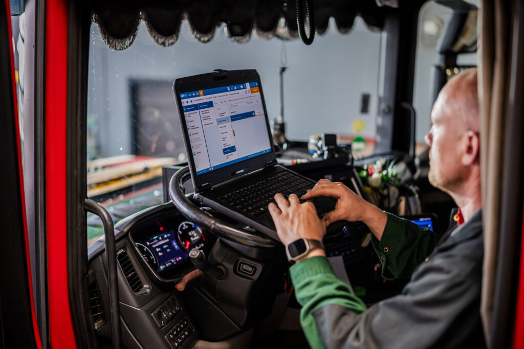 Chauffeur met laptop in de cabine
